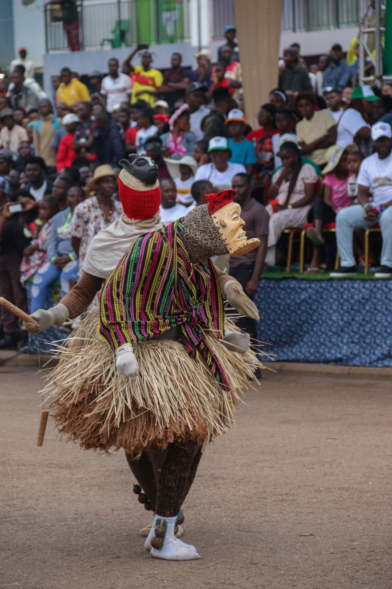 Masked dancers performing at an outdoor African festival