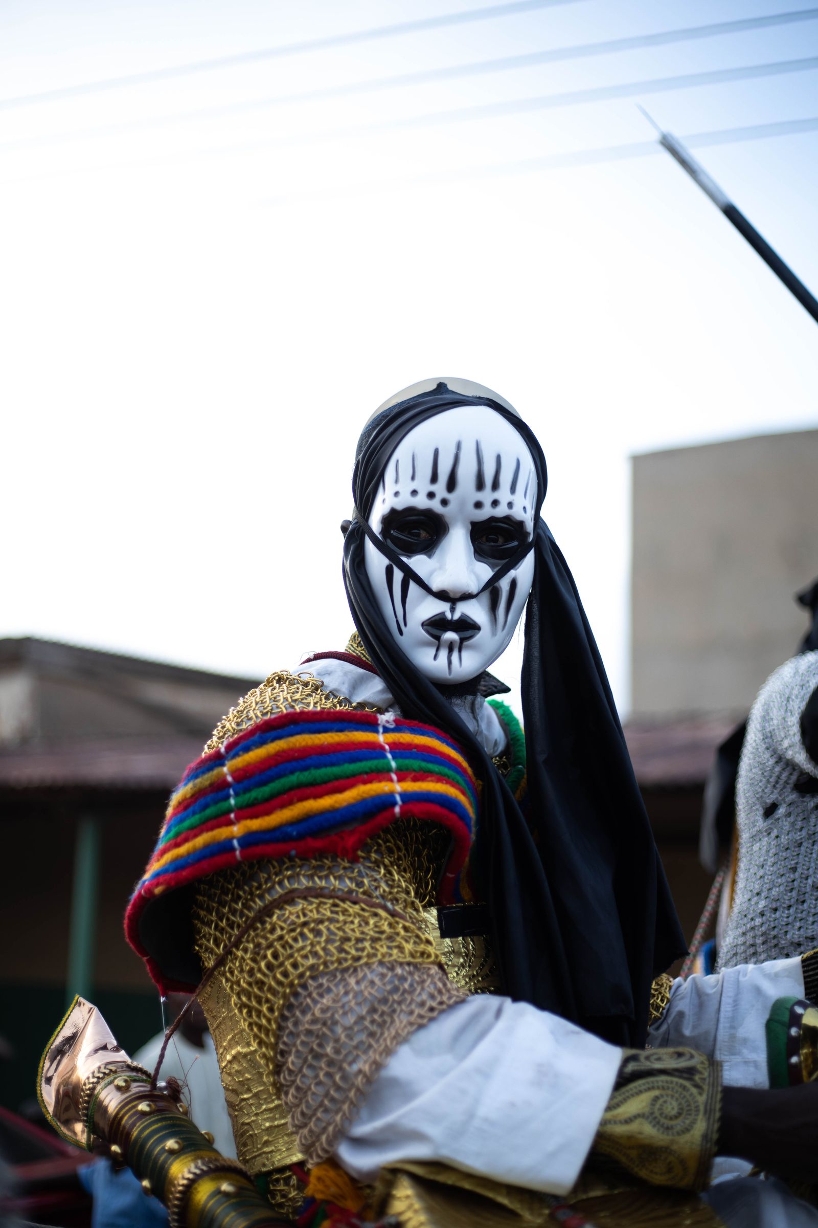 A masked performer in full costume at a Nigerian cultural festival