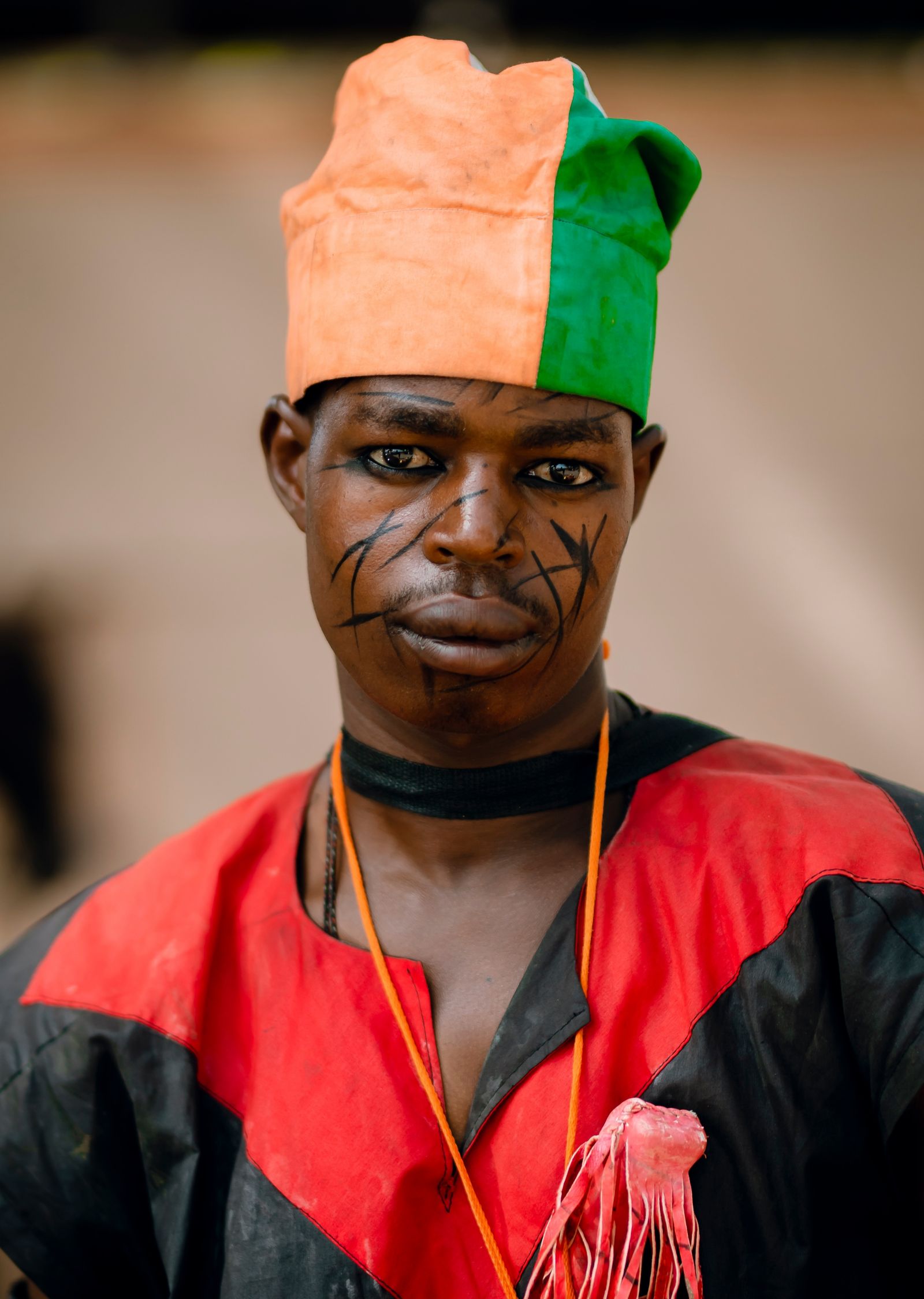 Portrait of a man in traditional Nigerian attire with facial marks