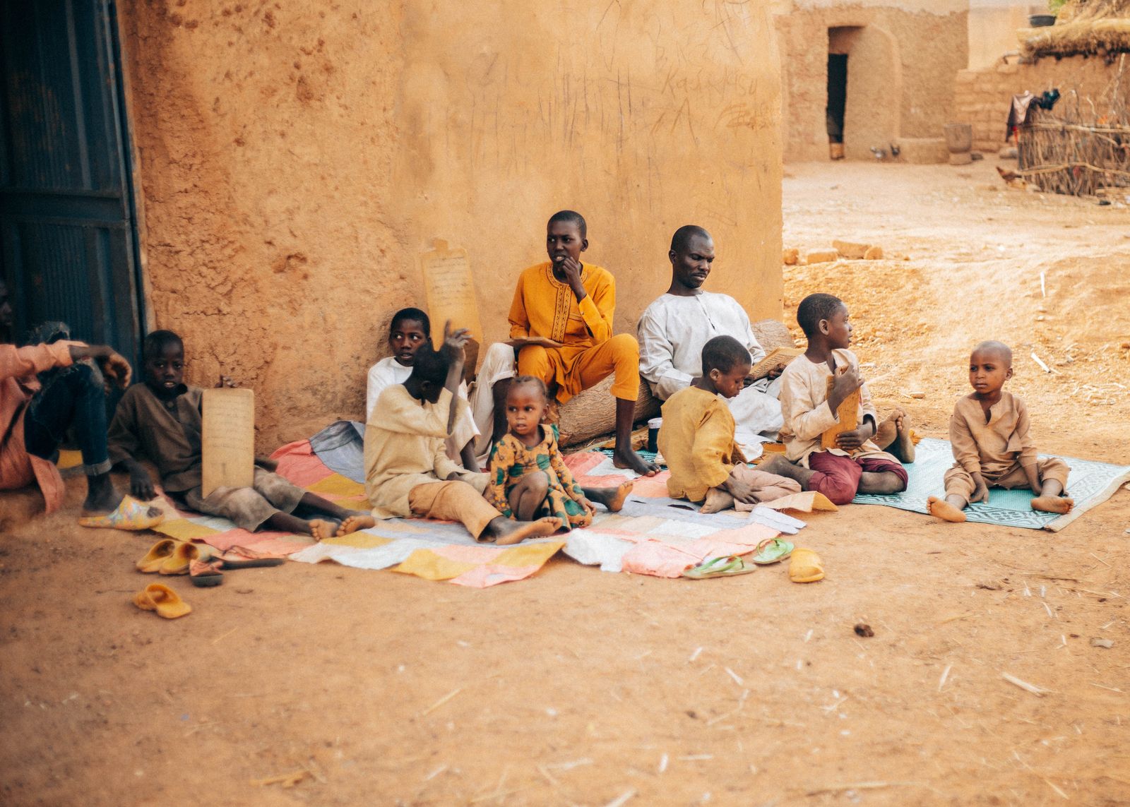 African children and elders learning together outdoors in a rural community