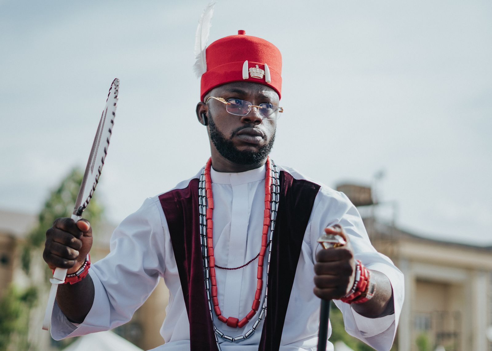 Portrait of a Nigerian man in traditional Igbo attire outdoors